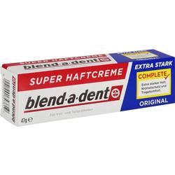 Eine rot-weiße Box mit starker Prothesen-Haftcreme liegt auf dem Tisch.